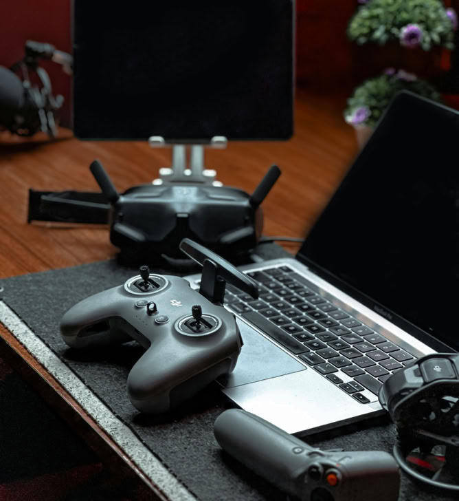 A sleek drone controller setup including a laptop and tablet in a modern office space.